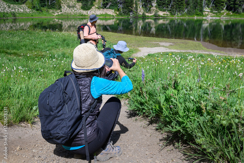 Obraz na płótnie Tourists taking photos of wildflowers by Shadow Lake. Sunrise area. Mount Rainier National Park. Washington State. w salonie