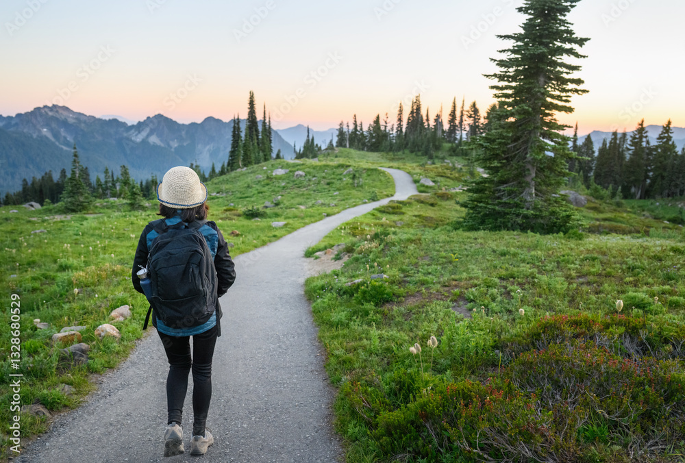 Solo female traveler hiking Paradise at sunset. Mount Rainier National Park. Washington State. USA.