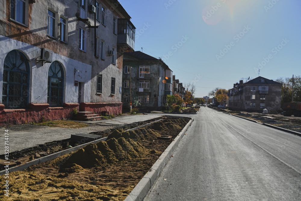 Fototapeta premium Autumn landscape of a small town. Village houses and roads covered with orange foliage