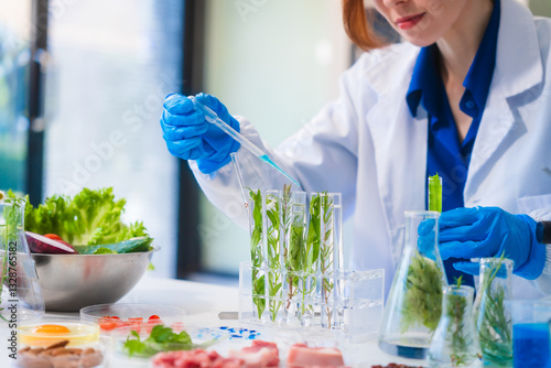 Middle-aged female laboratory worker wearing blue gloves conducts lab test on food ingredients lettuce, cucumber, pork. Using microscope, she analyzes nutrients, preservatives, food safety records.