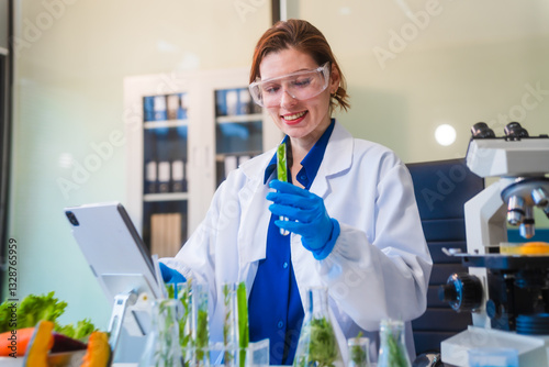 Middle-aged female laboratory worker wearing blue gloves conducts lab test on food ingredients lettuce, cucumber, pork. Using microscope, she analyzes nutrients, preservatives, food safety records.