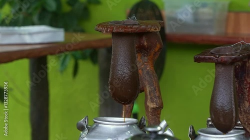 Landscape slow-motion shot of a chorreador during a coffee tour in La Fortuna, Costa Rica. The traditional wooden stand with a cloth filter slowly brews rich, flavorful coffee. photo