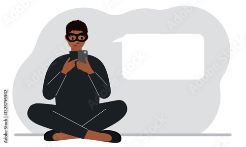Hacker in a black mask with a mobile phone. The cybercriminal is holding a smartphone. Cyber attack, mobile phishing, scam.