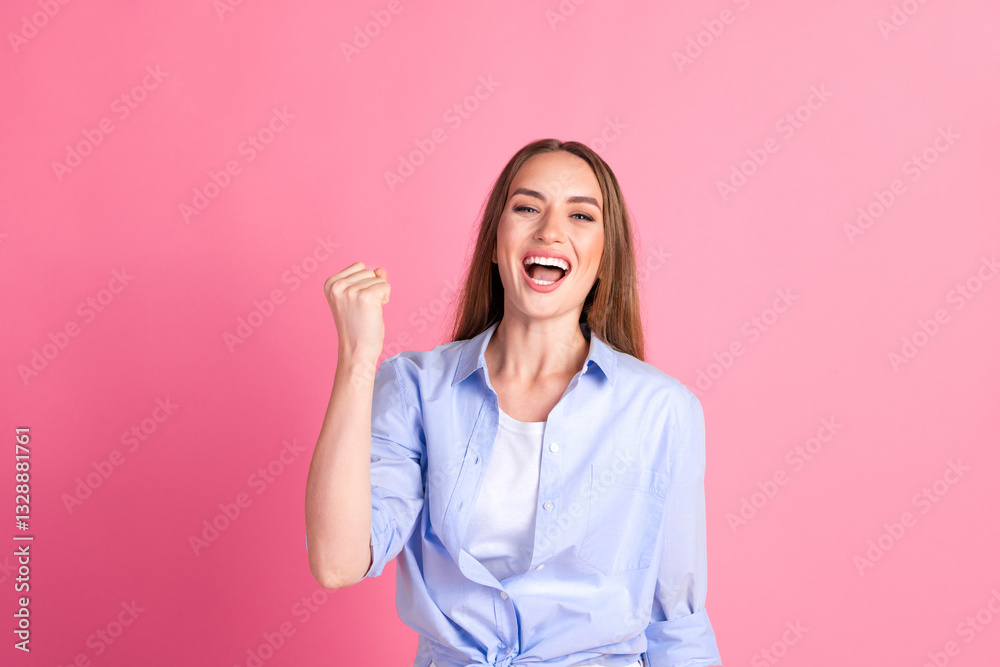Young woman celebrating success with a cheerful expression, casual style against a vibrant pink background, conveying happiness and positive energy. Young woman celebrating success with a cheerful expression, casual style against a vibrant pink background, conveying happiness and positive energy.