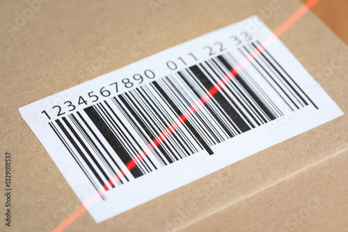 Parcel with label, closeup. Red laser light on barcode for scanning