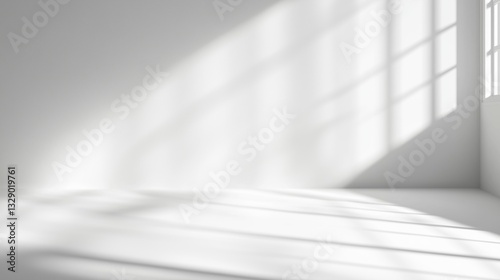 A white room with a window and a wall. The room is empty and has a lot of light coming in from the window