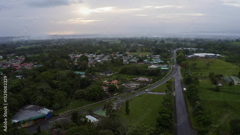 Aerial drone shot trucking right of La Fortuna, Costa Rica, a famous tourist town in the rainforest. A vibrant tropical city with overcast clouds, misty hills, and lush greenery on a rainy morning. Aerial drone shot trucking right of La Fortuna, Costa Rica, a famous tourist town in the rainforest. A vibrant tropical city with overcast clouds, misty hills, and lush greenery on a rainy morning.
