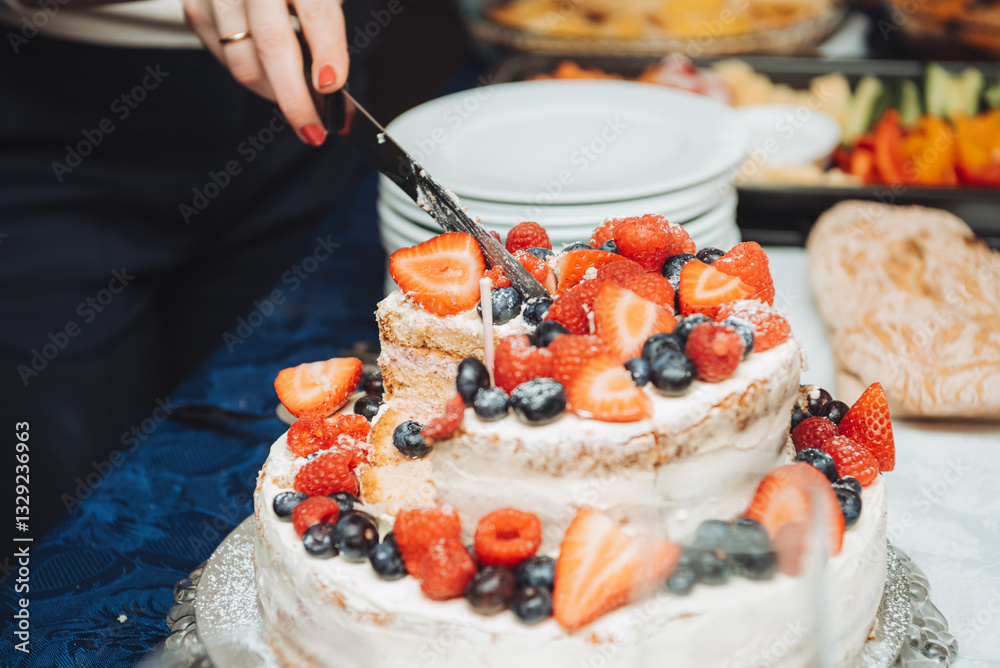 Festive cake with white cream, decorated with raspberries and strawberries