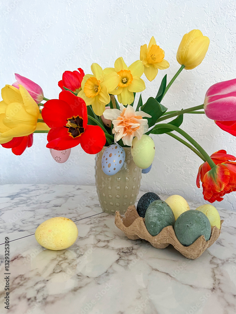 An Easter card. Colorful bright tulips decorated with eggs are in a vase on the table next to colorful eggs. Vertical photography