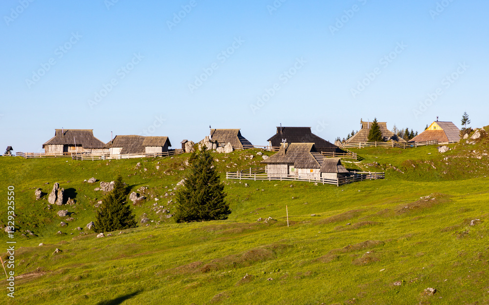 View of idyllic alpine pasture with rustic cabins and mountain huts in a serene mountain landscape, Velika Planina, Kamnik, Slovenia. View of idyllic alpine pasture with rustic cabins and mountain huts in a serene mountain landscape, Velika Planina, Kamnik, Slovenia.