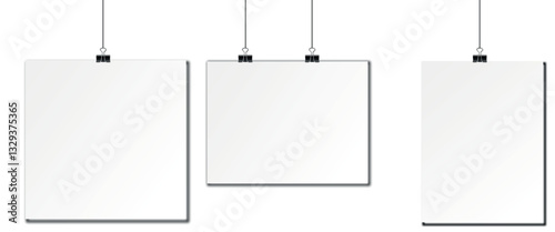 Blank white posters hanging on clips in a minimalistic studio setting