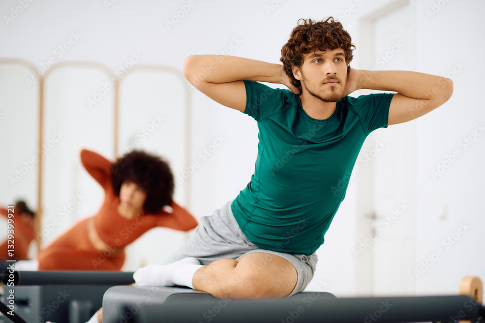 Obraz premium Engaging in a dynamic pilates session at a modern fitness studio for strength and flexibility