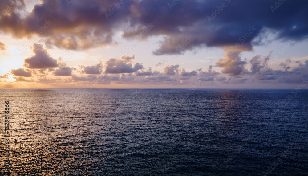 Obraz premium Stunning Seascape Background: Golden Sunrise or Sunset Over Calm Ocean Waters with Colorful Sky and Reflective Light Path - Perfect for Travel, Wellness, and Inspirational Designs