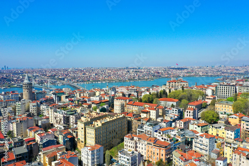 Aerial view of Istanbul and the Bosphorus Strait in Turkey on a sunny day. Aerial perspective showcasing the historic city center with its distinctive red-roofed buildings, the ancient Galata Tower