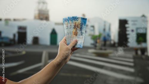 Man holding swiss franc banknotes on city street depicting outdoor urban scene with people moving in the background.