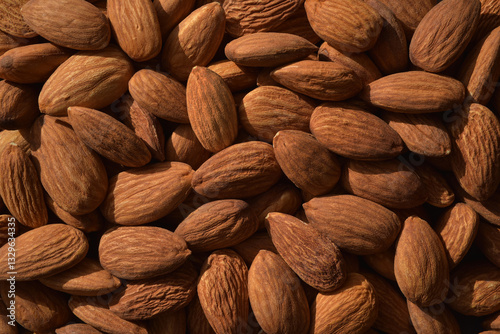 Photograph of dried almonds nuts in contrast lighting. Top view  almonds background. Healthy eating and snack, whole foods. Source of protein and magnesium.