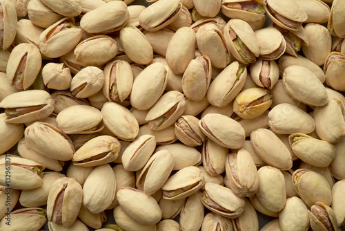 Photograph of roasted and salted pistachio nuts in diffused even light. Top view pistachios. Healthy eating, whole foods. 
