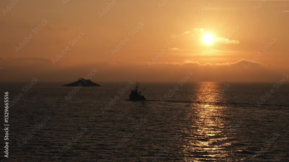 Fishing boat moving towards a deserted island and against dreamy sunset clouds. Ship silhouette and flying seagulls with golden water surface. View of the Adriatic Sea from Rovinj, Croatia. Fishing boat moving towards a deserted island and against dreamy sunset clouds. Ship silhouette and flying seagulls with golden water surface. View of the Adriatic Sea from Rovinj, Croatia.