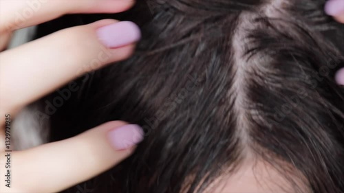 Woman touching her hair, showing gray roots, alopecia, and unwashed scalp condition.