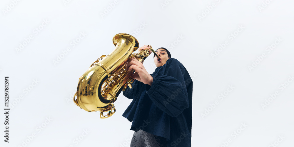 Φωτογραφία Low-angle view of female musician emotionally playing saxophone, fully lost in melody and performance against white background