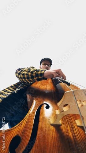 Fotografi Low-angle image of dedicated bassist immersed in deep, soulful performance, playing double bass against white background
