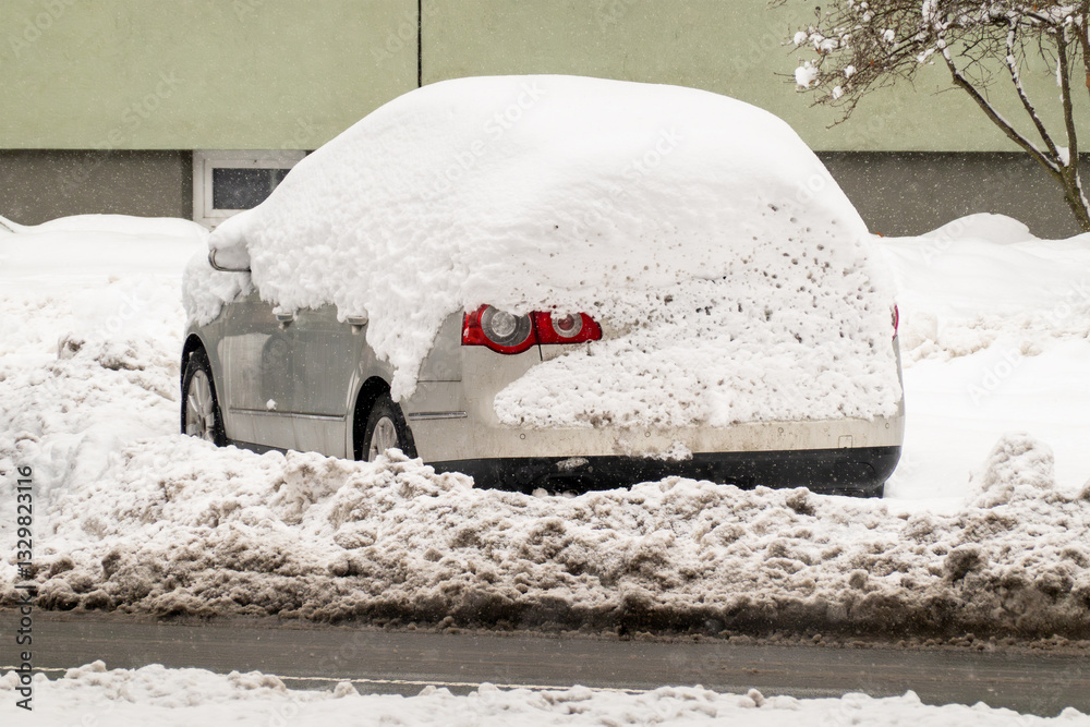 Unrecognizable car covered by large amount of snow, dirty by passing cars