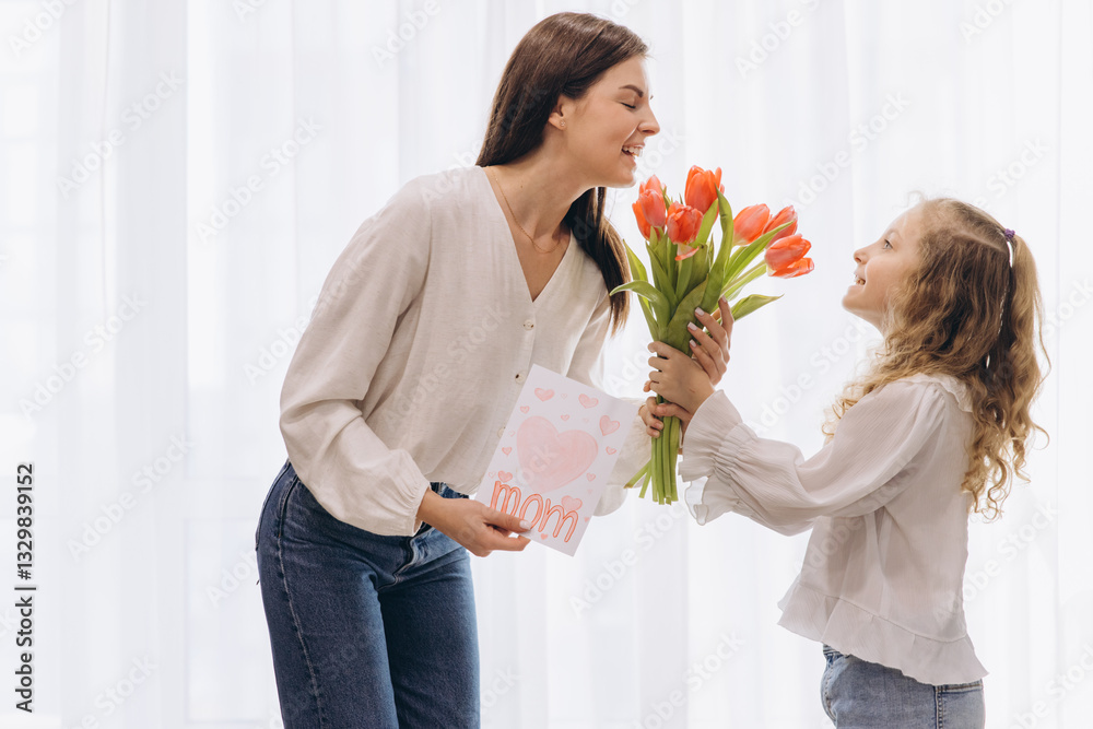 Daughter surprising her mother with tulips and greeting card for Mother's Day Daughter surprising her mother with tulips and greeting card for Mother's Day