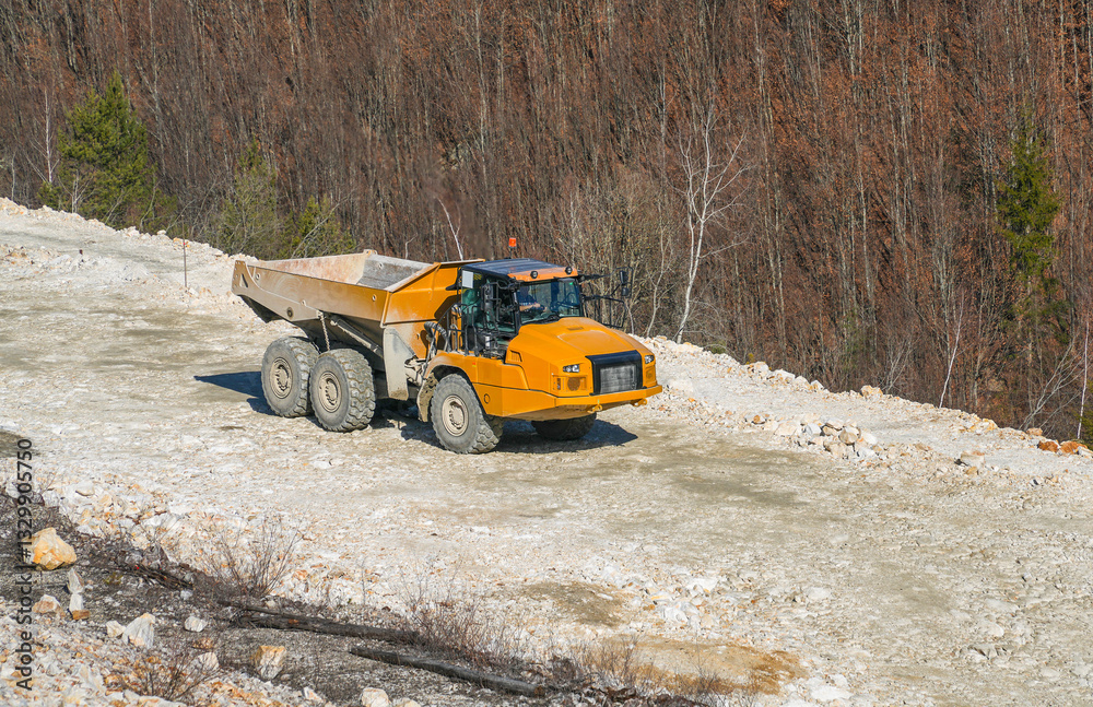 Image of a big yellow truck at work in a quarry