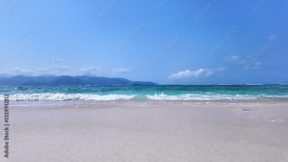 static shot of ocean with calm waves reaching shore of sand beach on tropical Gili island Indonesia during sunny day, holidays, vacations, relax, paradise and tourism concept, slow motion static shot of ocean with calm waves reaching shore of sand beach on tropical Gili island Indonesia during sunny day, holidays, vacations, relax, paradise and tourism concept, slow motion