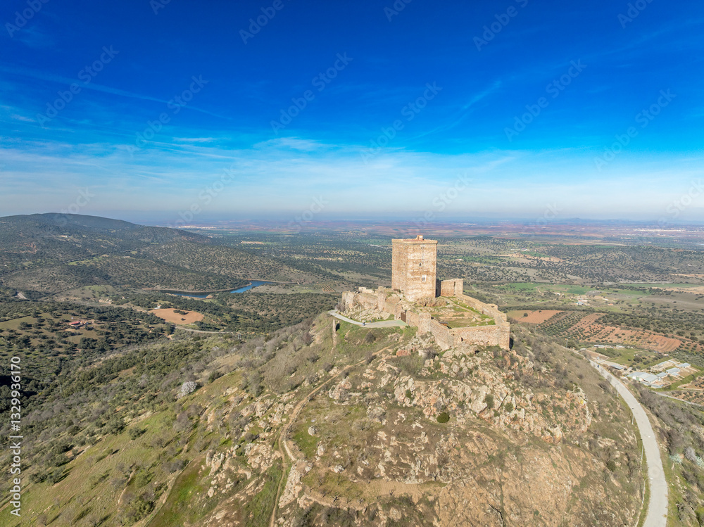 Aerial view of Feria castle in Spain, Gothic and Mudéjar style buildings, square keep, blue sky background