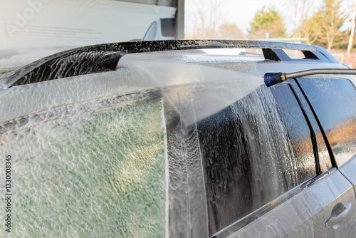 Obraz na plátně Washing an SUV with high-pressure water and foam at a self-service car wash, cle