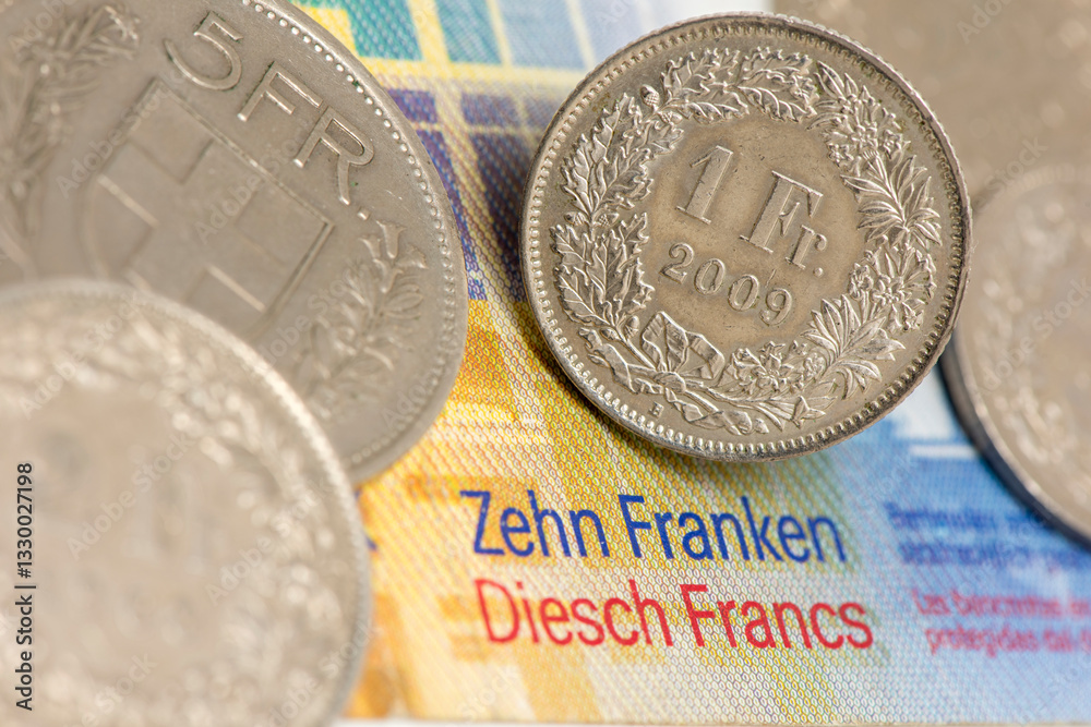 Auf einem Schweizer 10 Franken Geldschein liegt eine Münze Schweizer Franken