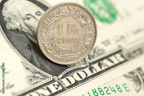 Auf einem US-Dollar-Schein liegt eine Münze Schweizer Franken