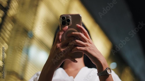 closeup hands of young girl with smart watch touching smartphone screen at night
