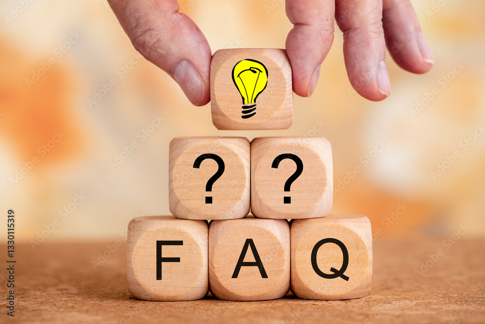 Mehrere Holzwürfel bilden eine Pyramide und sind bedruckt mit Fragezeichen und FAQ, darüber eine Hand mit einem Holzwürfel bedruckt mit einem Glühbirne als Symbol für Idee oder Geistesblitz