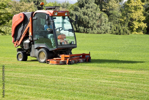 Professional motorized ride on lawn mower cutting fresh grass