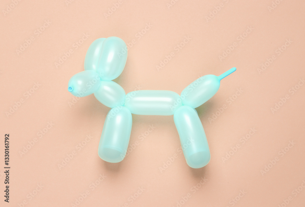 Blue balloon in the shape of a dog on a pink background. Top view Blue balloon in the shape of a dog on a pink background. Top view