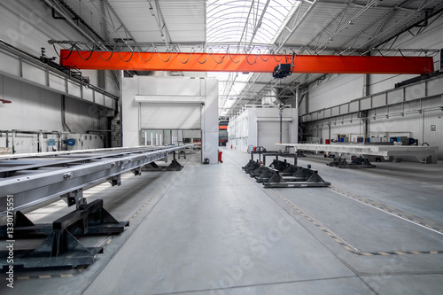 A large industrial building with a red crane hanging from the ceiling