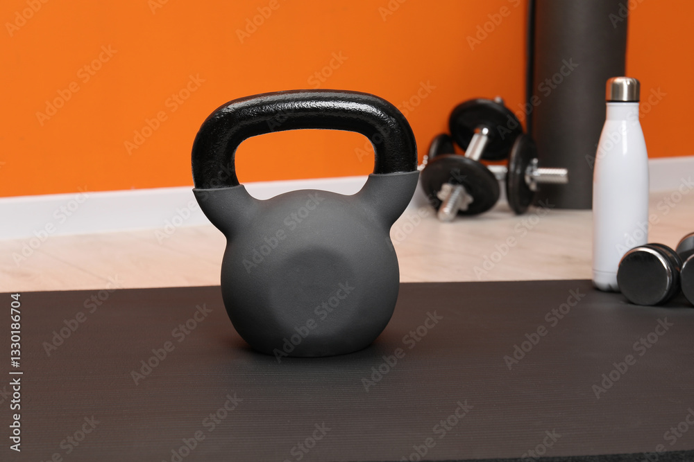 Fototapeta premium One kettlebell on mat indoors. Sport equipment
