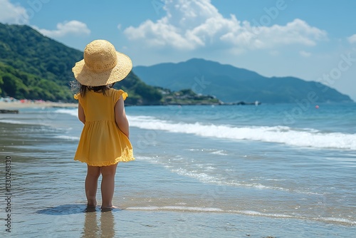 Little girl in yellow dress at beach.