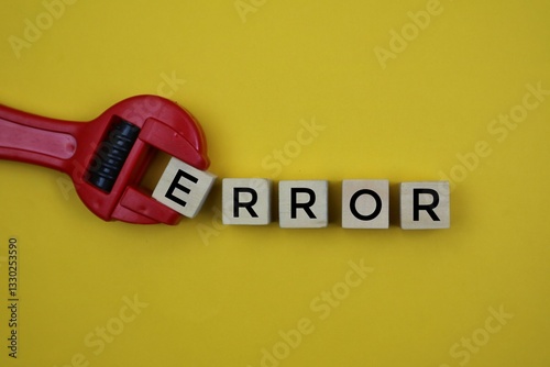 A tool holding a wooden block with the word 'error' written on it isolated on a yellow background, expressing an error or problem in a creative way.