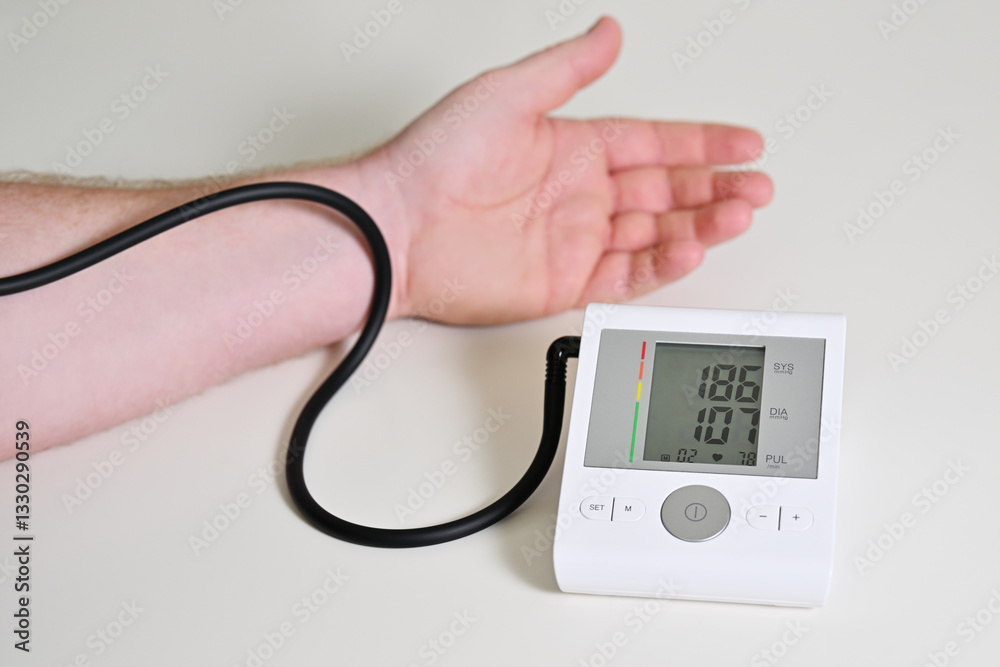 Electronic blood pressure monitor and male hand Electronic blood pressure monitor and male hand