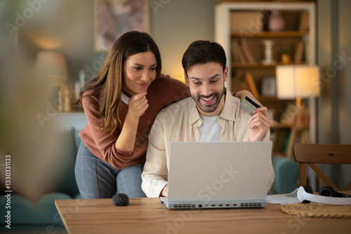 Wallpaper Mural Couple using laptope to buy online. Man holding credit card to pay bills online Torontodigital.ca
