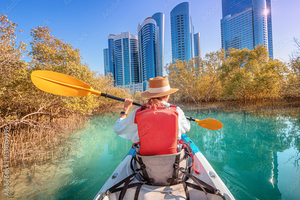 Tourist paddling on a kayak in mangrove Al Reem island mangrove park in Abu Dhabi, United Arab Emirates
