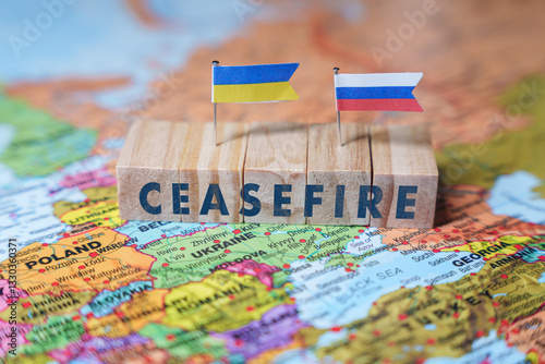 Wooden blocks spelling Ceasefire with Ukrainian and Russian flags on a EUROPE map, symbolizing diplomacy, conflict resolution, and hopes for reconciliation
