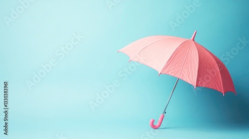 Pastel pink umbrella against a light teal background photo
