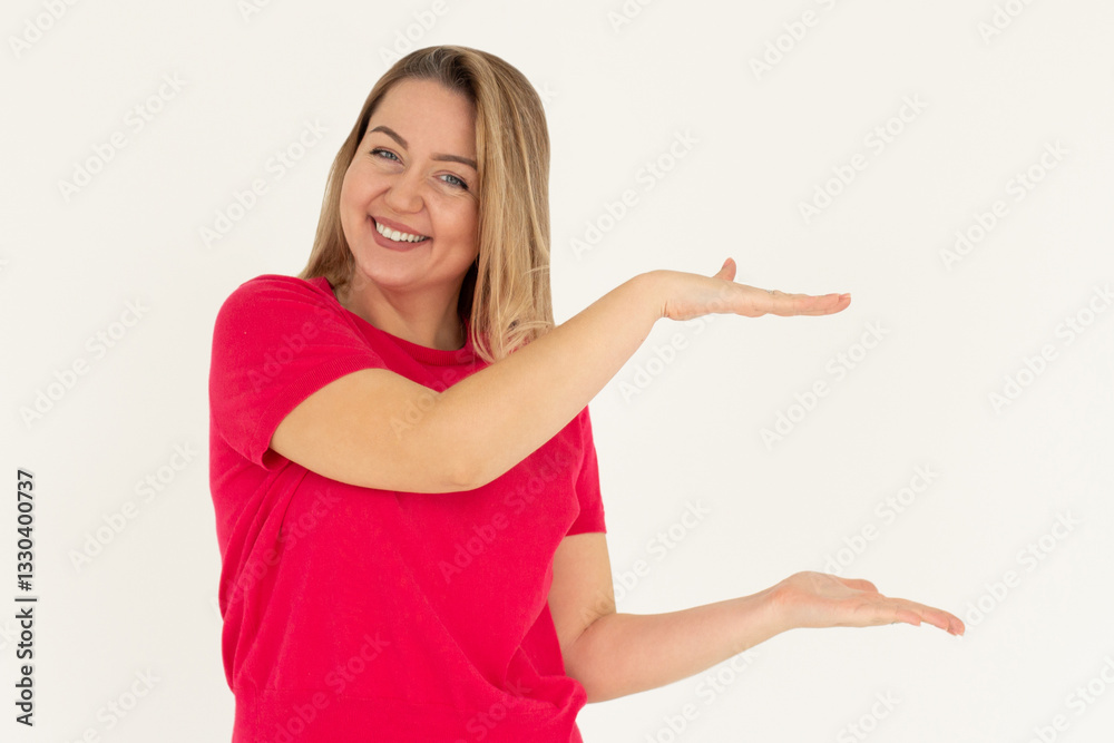 Adult confident woman showing logo on empty space between arms. Smiling girl inviting or advertising promo deal, pointing hands right and looking at camera, white background. Adult confident woman showing logo on empty space between arms. Smiling girl inviting or advertising promo deal, pointing hands right and looking at camera, white background.