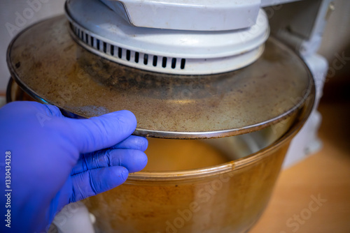 Removing grease on kitchen utensils.Fat deposits on the pan.A gloved hand cleans the cooking utensils.