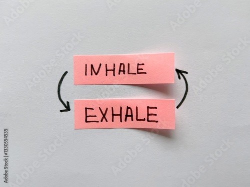 Obraz na plátně Two pink sticky notes with handwritten words “inhale” and “exhale,” connected by
