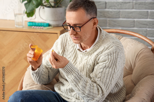 Middle-aged man taking pill...